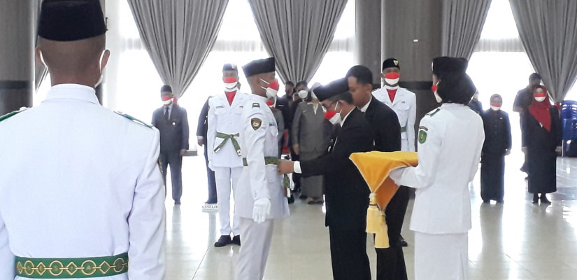 Pengikatan tali pinggang dan penyematan lencana oleh Bupati Kutim Ardiansyah Sulaiman kepada salah satu perwakilan Paskibraka Kutim.