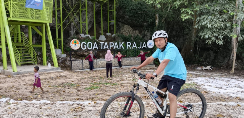 Kepala Desa Wonosari, Kabupaten PPU, Provinsi Kalimatan Timur, Kasiyono saat menggunakan sepeda mengitari wisata Goa Tapak Raja yang kian bersolek.