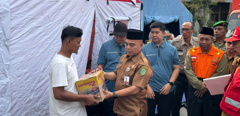 Asisten I Sekretariat Daerah Kukar, Akhmad Taufik Hidayat saat salurkan bantuan bagi warga terdampak kebakaran di Kelurahan Melayu, Tenggarong. (Selasar/Farid)